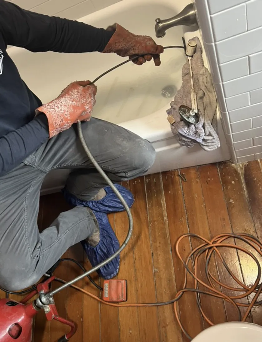 Blocked bathtub drain cleared with a motorized drain cable