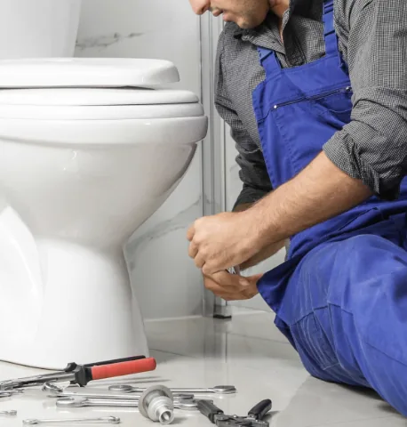 Plumber repairing a toilet