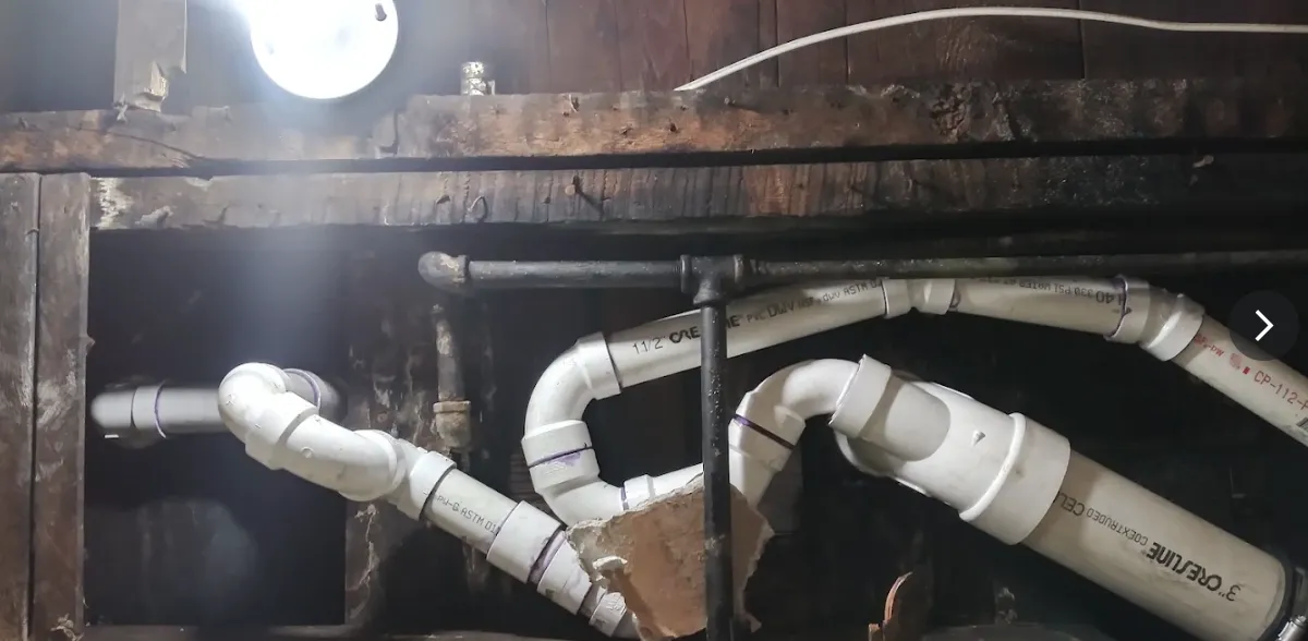 New PVC drain and vent piping run through open floor framing