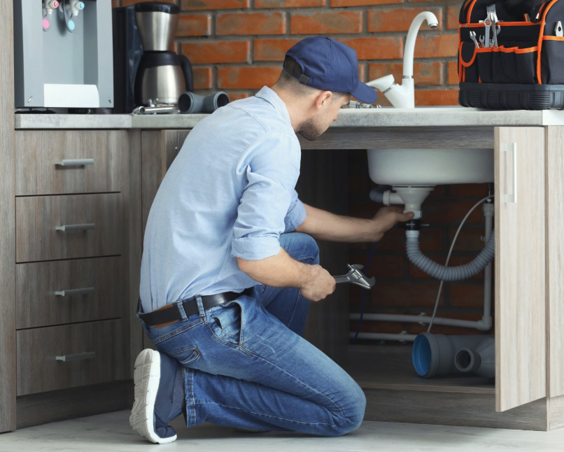 Plumber working under a kitchen sink