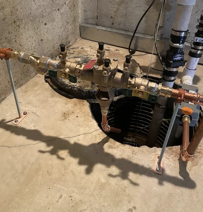 New backflow preventer and copper supply line set above a sump pit